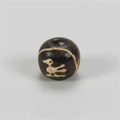 Lot 1201 - A ‘JATIM’ DARK BLUE GLASS BEAD WITH BIRD