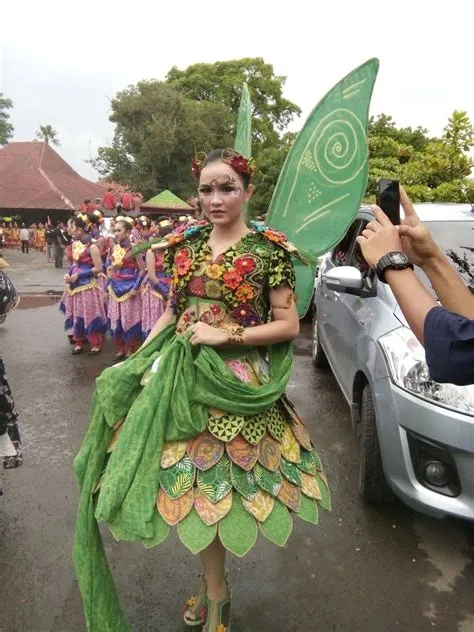 a woman dressed as a fairy holding a green leaf in front of a group of ...