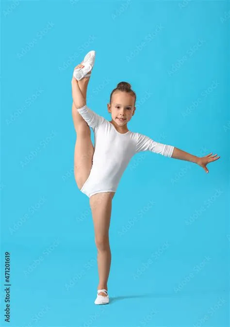 Little girl doing gymnastics on color background Photos | Adobe Stock