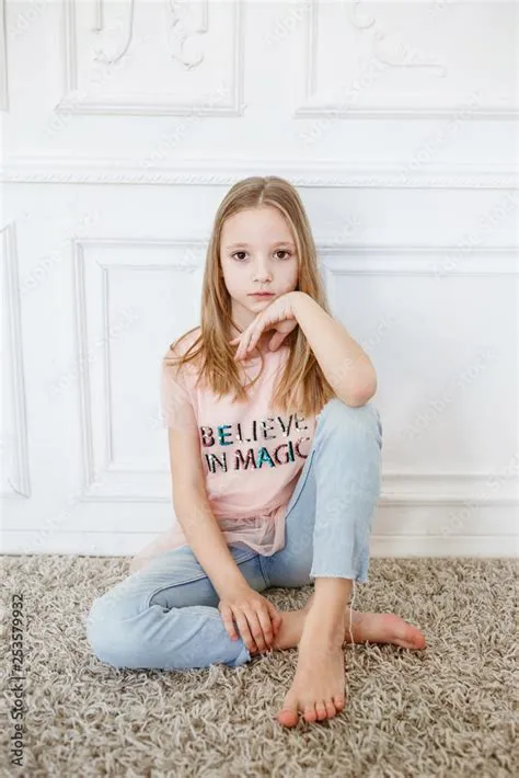 Cute pre-teen girl wearing fashion clothes posing in white interior ...