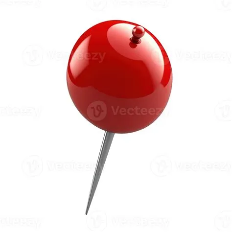 A bright red push pin is seen positioned diagonally on a clear ...
