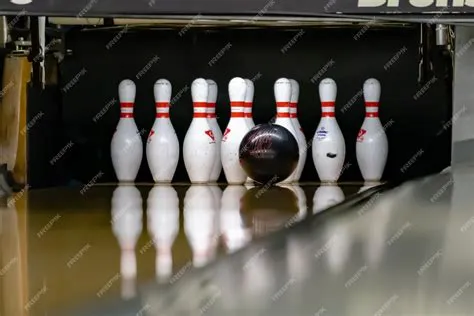 Premium Photo | Bowling ball hitting pins at a bowling alley