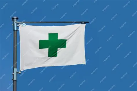 Premium Photo | A green cross sign, safety first aid flag on blue sky ...